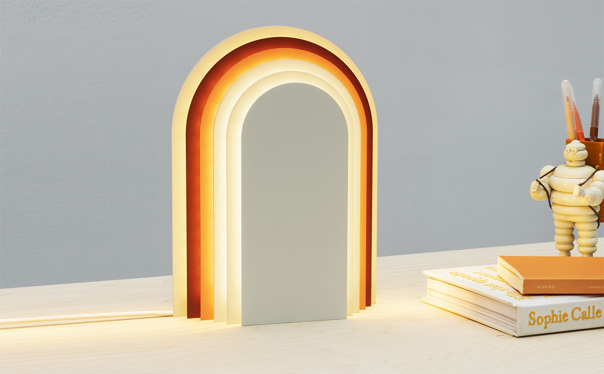 Lampe à poser design tons blancs et rouge allumée