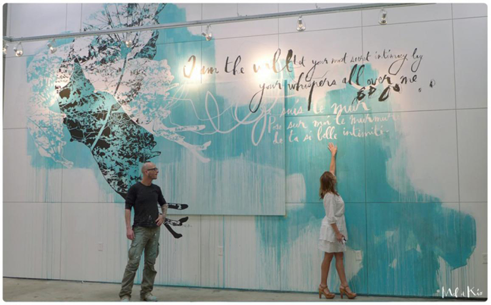 Portait des artistes muraux Mel et Kio devant une de leur réalisation